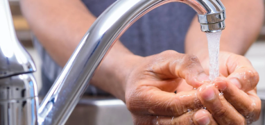 Person washing hands under tap